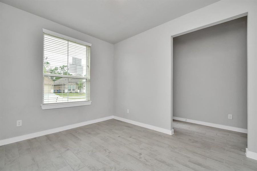 At the forefront, a refined home office beckons productivity and focus. Luxurious details like wood-look tile flooring, custom paint, expansive windows with privacy blinds, and French doors create an inspiring workspace. Sample photo of completed home with similar plan. As built color and selections may vary.