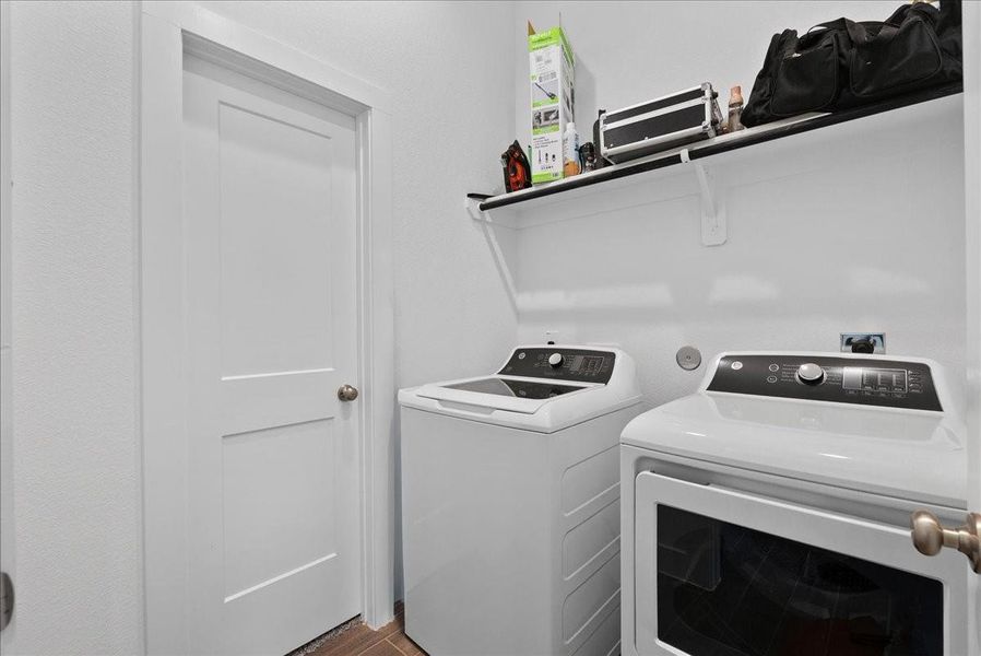 Indoor laundry offers exceptional convenience with direct access from the living area and a private connection to one of the primary closets, creating a functional and efficient everyday space. Indoor laundry offers exceptional convenience with direct access from the living area and a private connection to one of the primary closets, creating a functional and efficient everyday space.