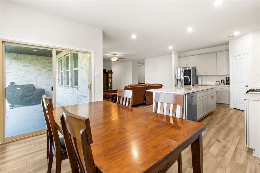 Dining space with light wood finished floors, a ceiling fan, and recessed lighting Dining space with light wood finished floors, a ceiling fan, and recessed lighting