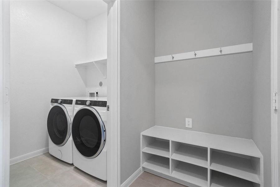 This dedicated area features a custom built-in bench with hooks, perfect for organizing coats, bags, and shoes right off the main hallway, keeping the rest of the home tidy.