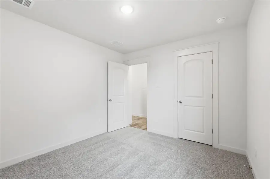 Unfurnished bedroom with carpet floors and baseboards Unfurnished bedroom with carpet floors and baseboards