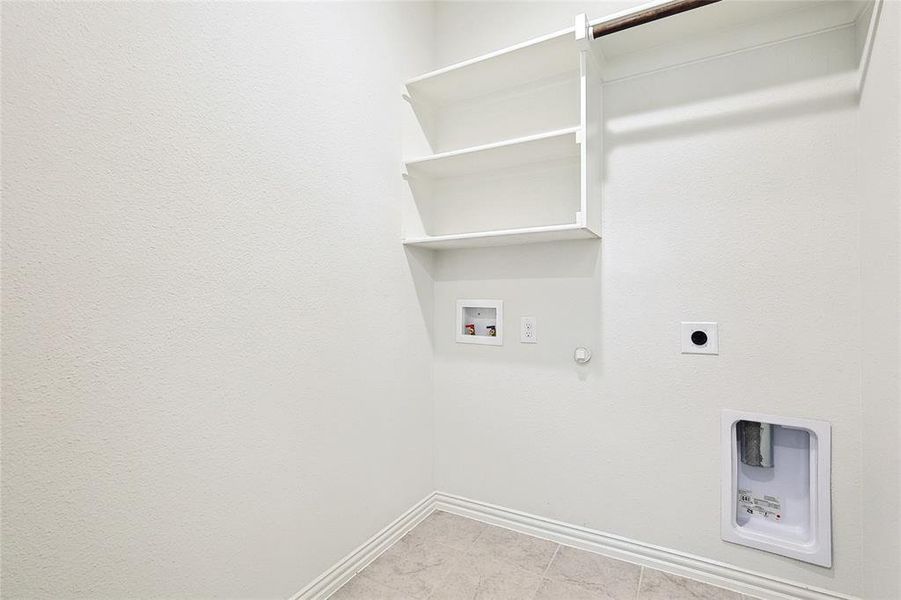 Clothes washing area with hookup for a washing machine, electric dryer hookup, light tile patterned floors, and gas dryer hookup