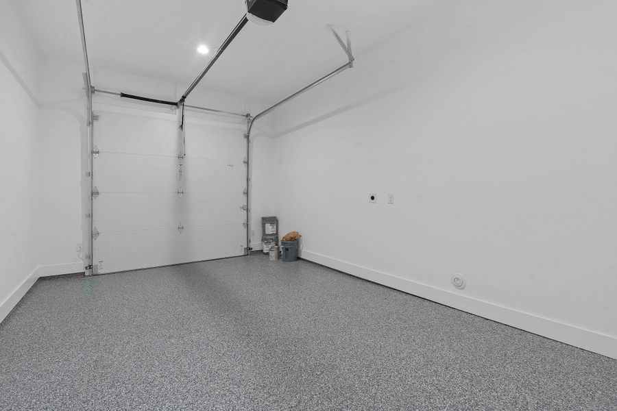Garage featuring baseboards and a garage door opener Garage featuring baseboards and a garage door opener