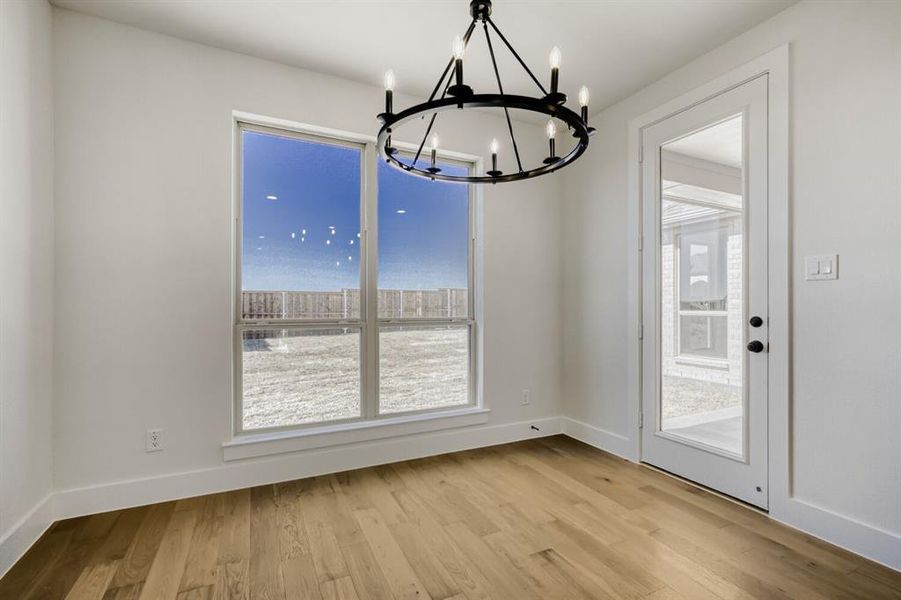 Unfurnished dining area with light wood-type flooring and a chandelier