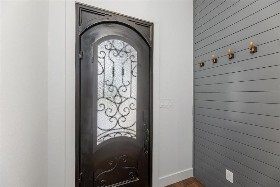 Foyer featuring wooden walls, baseboards, and wood finished floors