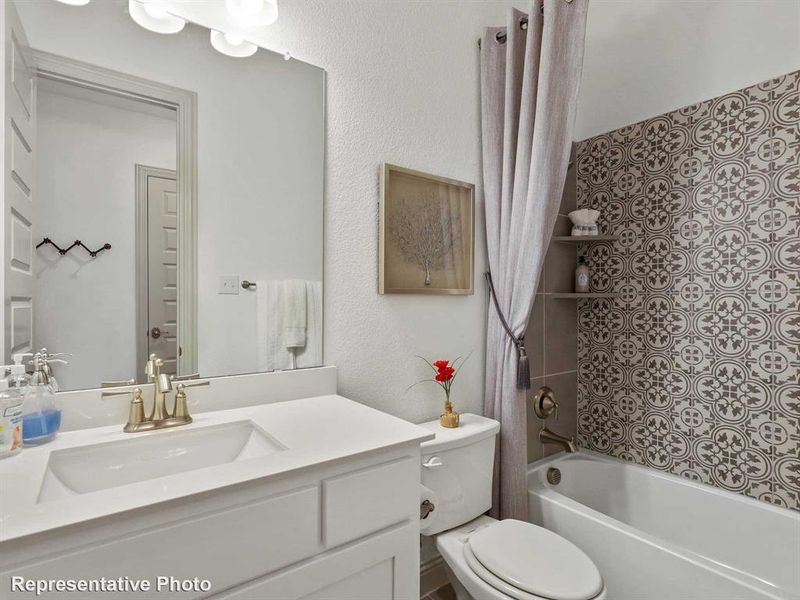 Bathroom with shower / tub combo, vanity, and a textured wall Bathroom with shower / tub combo, vanity, and a textured wall