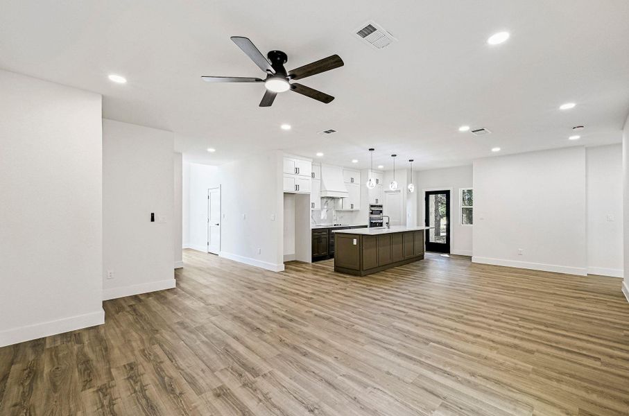 Kitchen with open floor plan, pendant lighting, white cabinets, recessed lighting, and light wood-type flooring