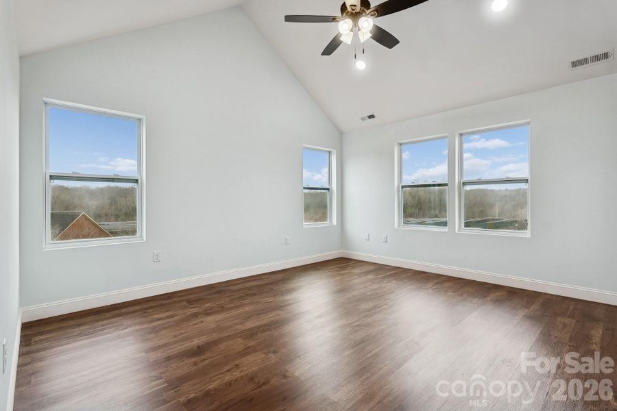 Primary bedroom on second level with cathedral ceiling, ceiling fan and recessed lighting