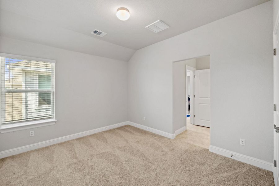 Spare room featuring vaulted ceiling and light carpet Spare room featuring vaulted ceiling and light carpet