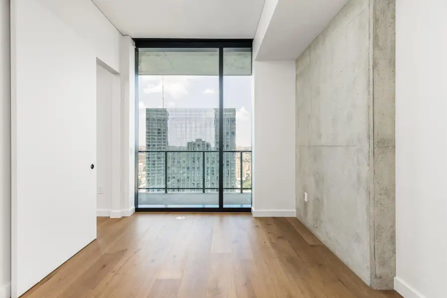 Floor-to-ceiling windows reveal a dynamic urban panorama from your bedroom.