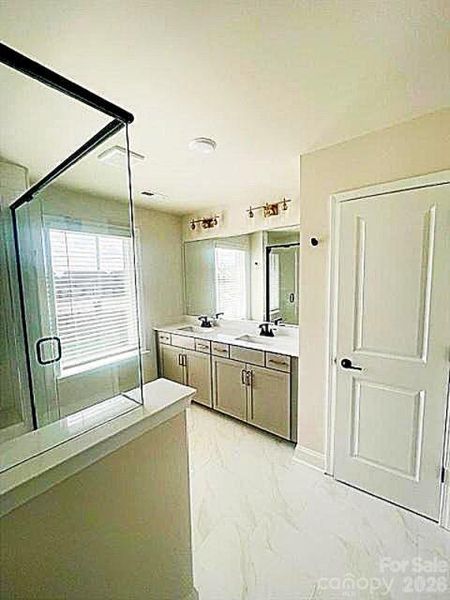 Primary bathroom with dual vanity soft close doors & drawers, large shower with bench , separate toilet. linen closet and WIC