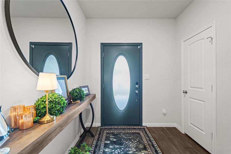 A welcoming entry features rich wood-look flooring and a stylish console table, perfect for greeting guests.