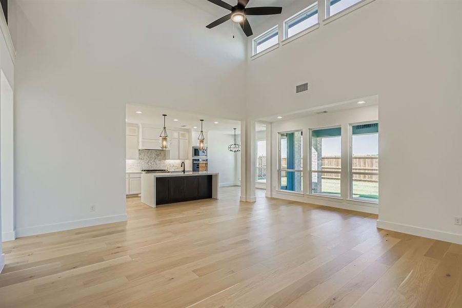 Unfurnished living room featuring light wood finished floors, ceiling fan, and recessed lighting