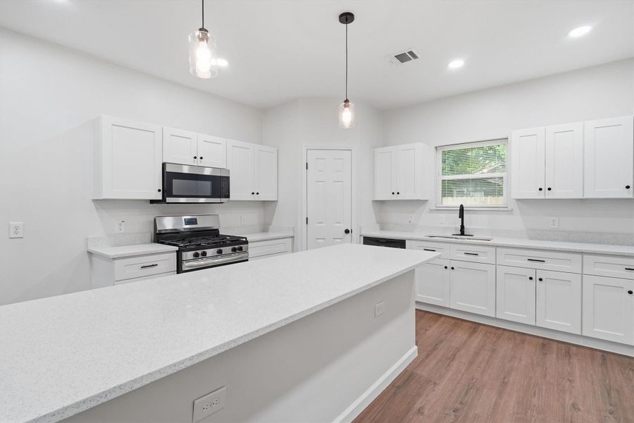 Light and bright kitchen with extra large island, stainless steep appliances