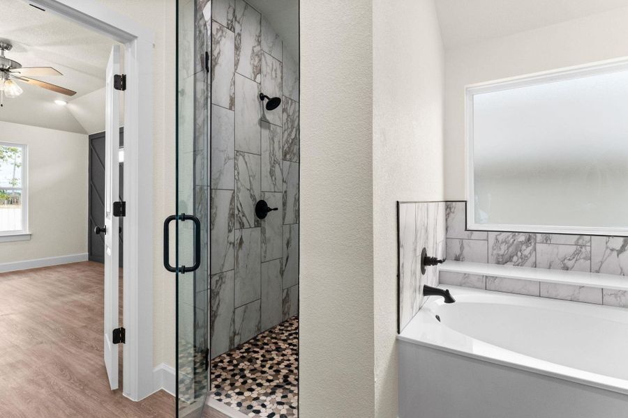 Full bathroom with a bath, a marble finish shower, vaulted ceiling, and wood finished floors