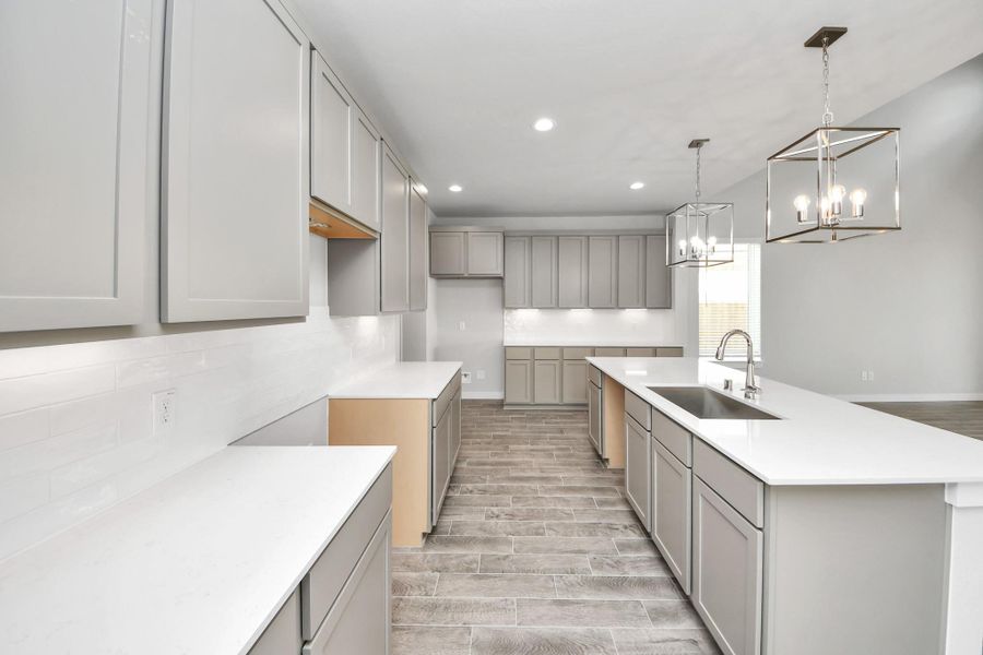 This kitchen is truly a chef's dream! This haven Boasts high ceilings, recessed & pendant lighting, stained wood cabinets, granite countertops, stainless steel appliances, a modern tile backsplash.  All of this overlooks your expansive family room, creating a perfect space for culinary delights and family gatherings.