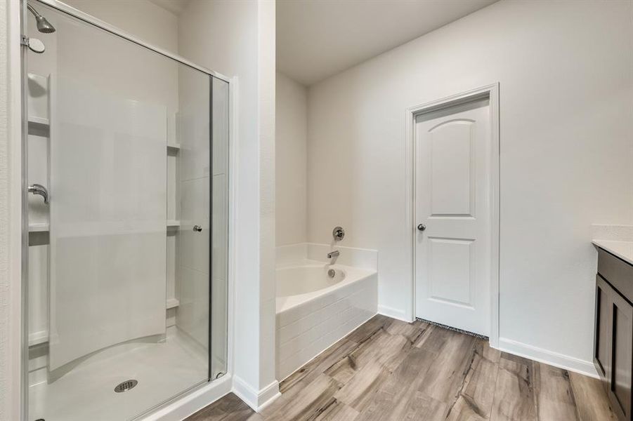 Bathroom featuring vanity, shower with separate bathtub, and wood-type flooring