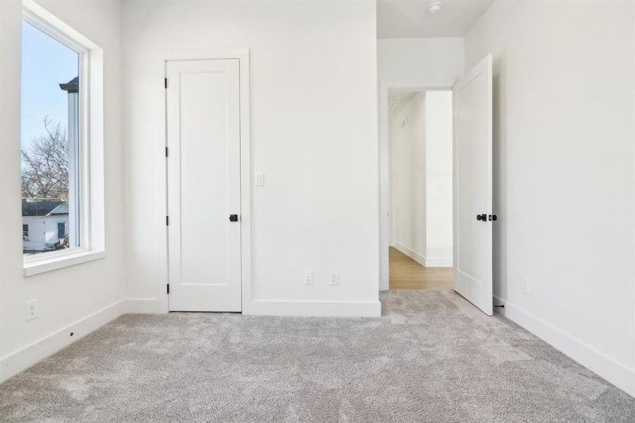 Unfurnished bedroom with light carpet