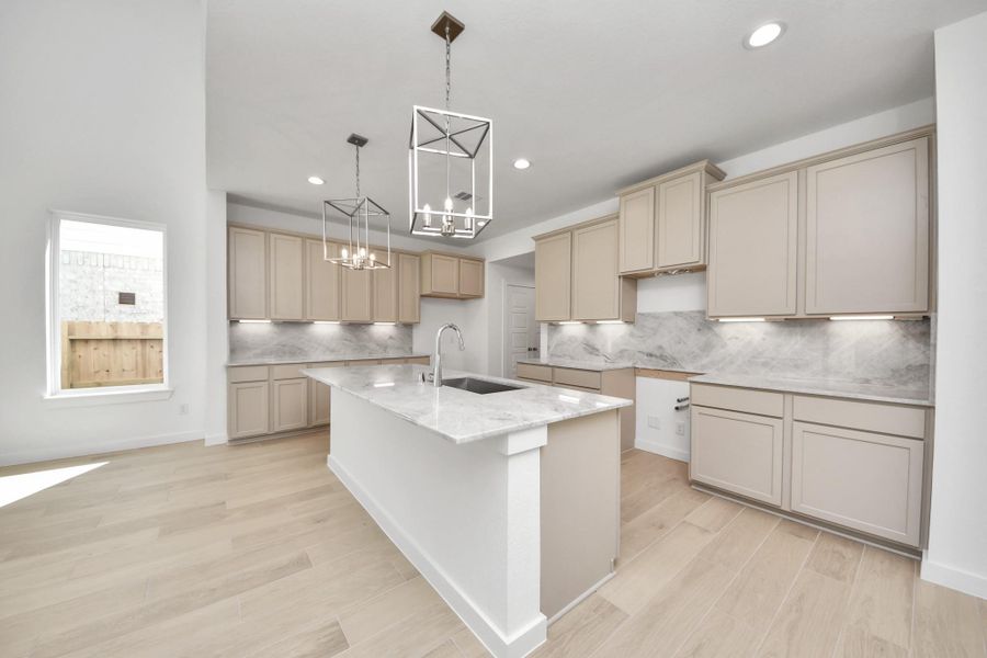 This kitchen is by far any chef’s dream! This spacious kitchen features high ceilings, light stained wood cabinets, granite countertop, SS appliances, modern tile backsplash, recessed lighting, extended counter space, granite kitchen island, and space for breakfast bar, and a walk-in pantry all overlooking your huge family room. Sample photo of completed home with similar floor plan. Actual colors and selections may vary.
