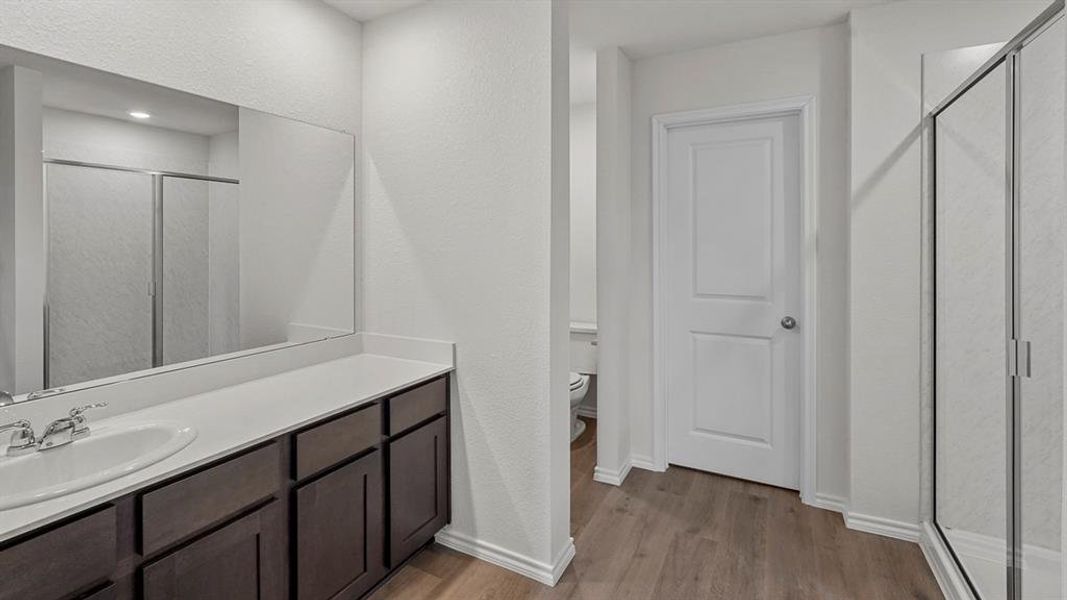 Bathroom featuring a vanity with dark wood-finish cabinetry, a white countertop, and a single basin sink