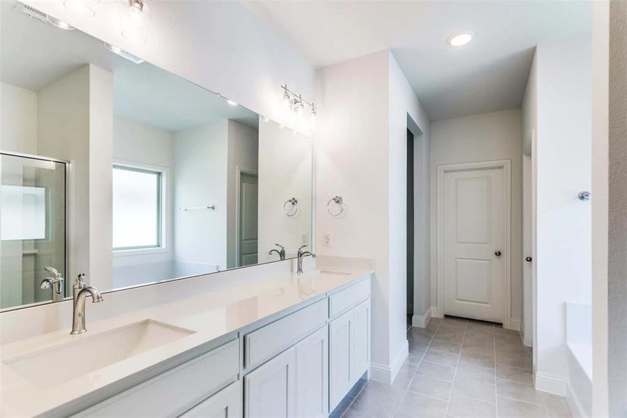 Bathroom with vanity, tile patterned floors, and an enclosed shower