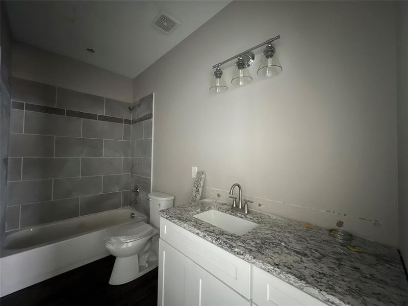 Full bathroom with vanity, toilet, and tiled shower / bath