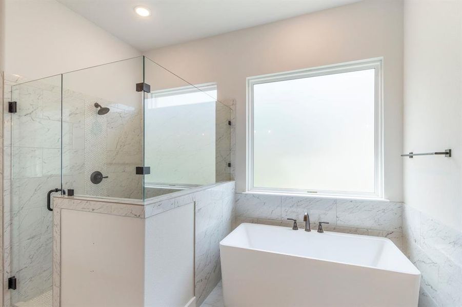 Bathroom with tile walls and separate shower and tub