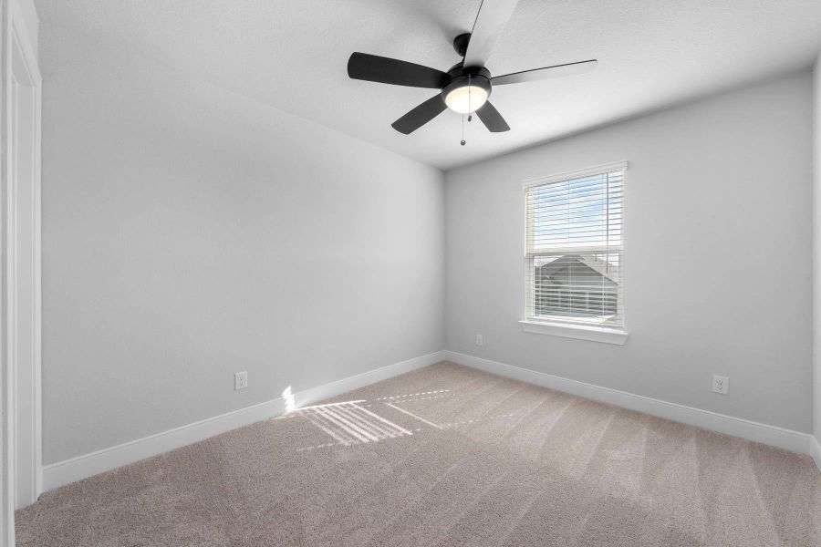 Spare room featuring light carpet and ceiling fan