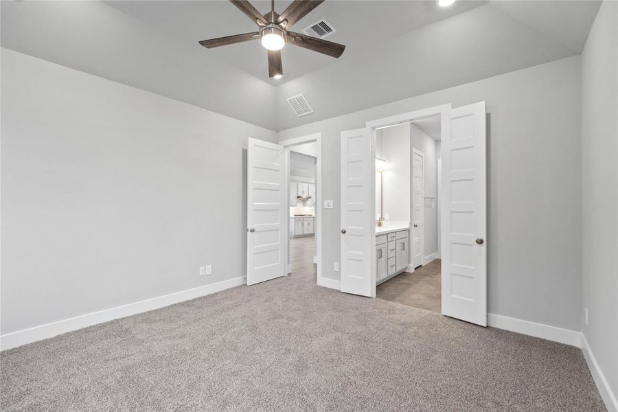 Additional view from primary bedroom looking towards the double door entrance to primary bathroom.