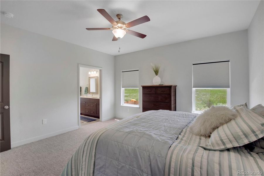Bedroom with light carpet and a ceiling fan
