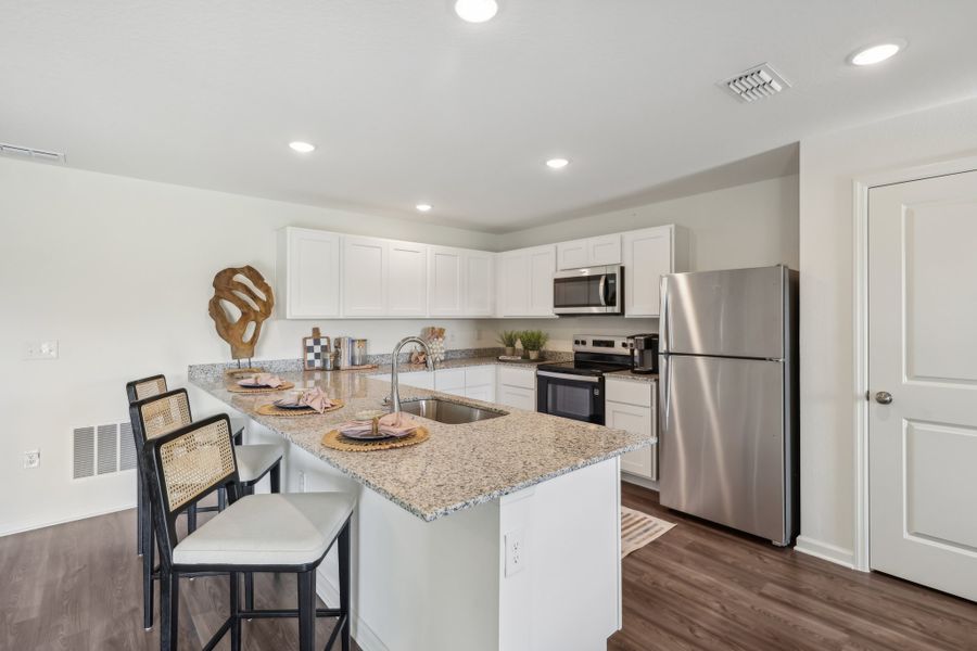 A kitchen with white cabinets.