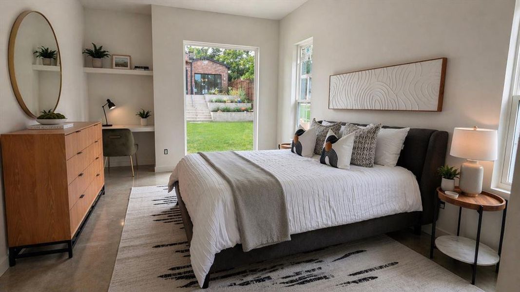 Guesthouse bedroom with built in desk and a view of the pool.