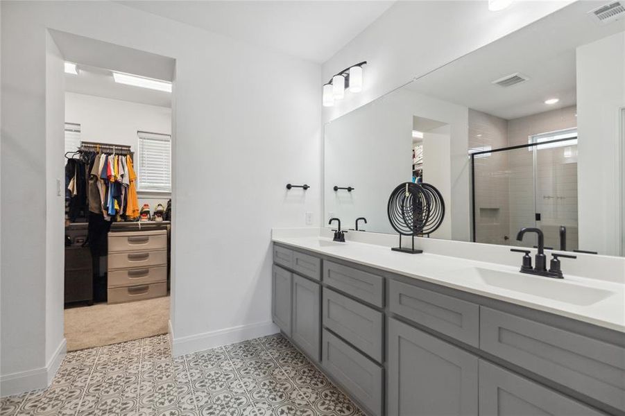 Full bath with a spacious closet, visible vents, a sink, baseboards, and a stall shower Full bath with a spacious closet, visible vents, a sink, baseboards, and a stall shower