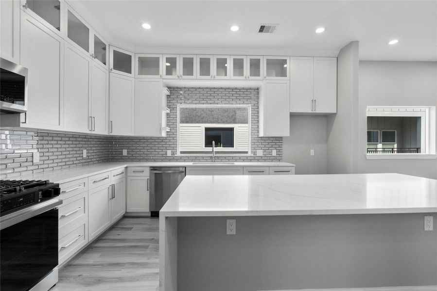 Kitchen is equipped with a gas range, Quartz counters and a shaker style cabinets Kitchen is equipped with a gas range, Quartz counters and a shaker style cabinets