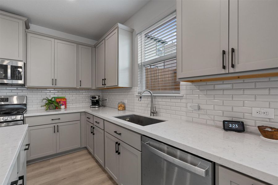 Kitchen featuring stainless steel appliances, gray cabinets, center island, and recessed lighting