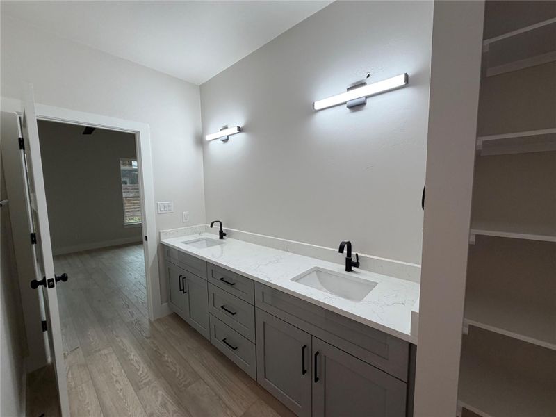 Double vanity with quartz counters and modern fixtures define this primary bathroom.