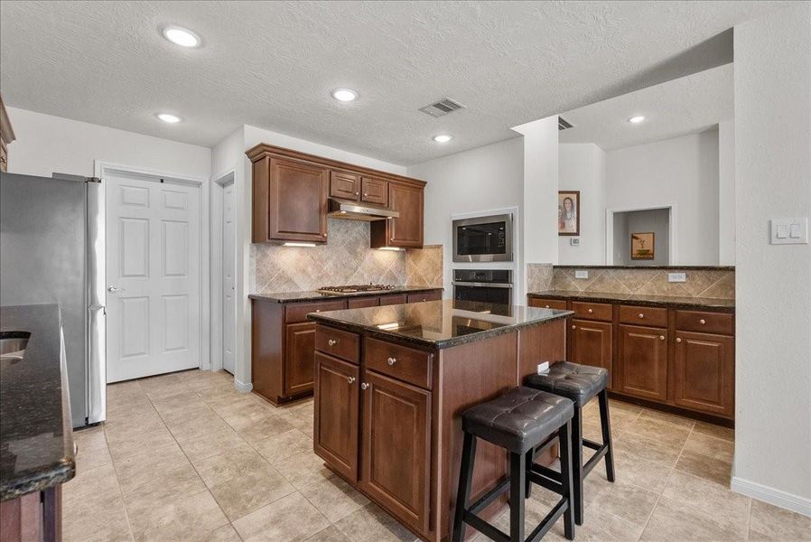 Chef's eat-in island kitchen features 42" cabinets with crown molding, granite countertops, stainless steel appliances and a breakfast bar Chef's eat-in island kitchen features 42" cabinets with crown molding, granite countertops, stainless steel appliances and a breakfast bar