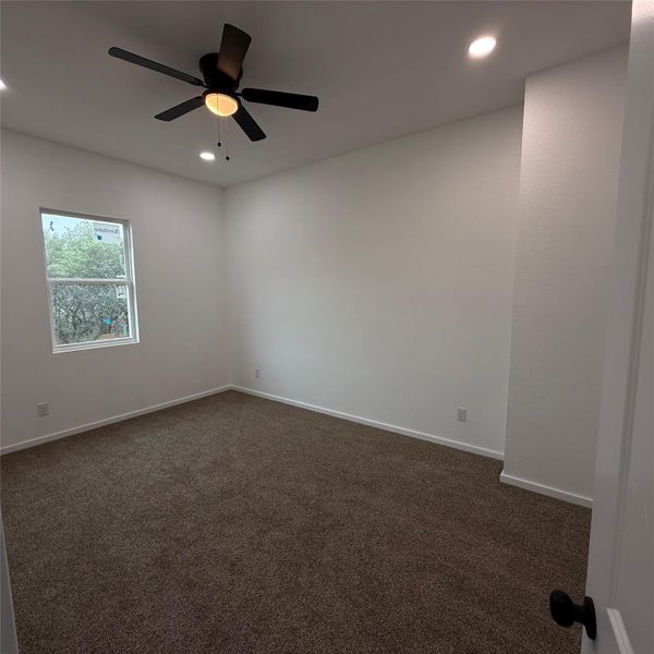 Room with neutral brown carpeting, white baseboards, and white walls