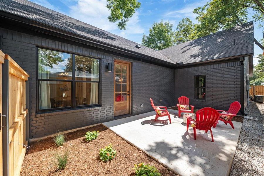 Back of property with brick siding, a patio area, roof with shingles, and an outdoor fire pit Back of property with brick siding, a patio area, roof with shingles, and an outdoor fire pit