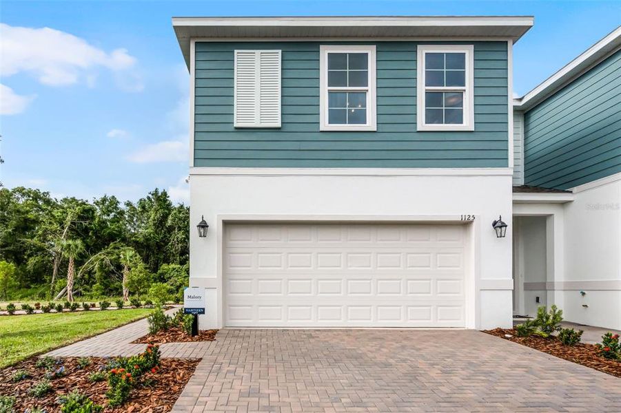 Front exterior of a new home in Delaney Reserve, Deland, FL, highlighting curb appeal (Image 1). Front exterior of a new home in Delaney Reserve, Deland, FL, highlighting curb appeal (Image 1).