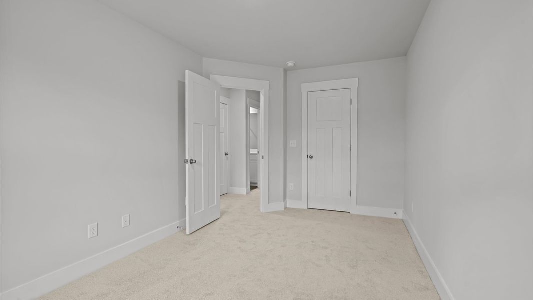 Elegant bedroom retreat featuring soft carpeting and a thoughtfully designed walk-in closet Elegant bedroom retreat featuring soft carpeting and a thoughtfully designed walk-in closet