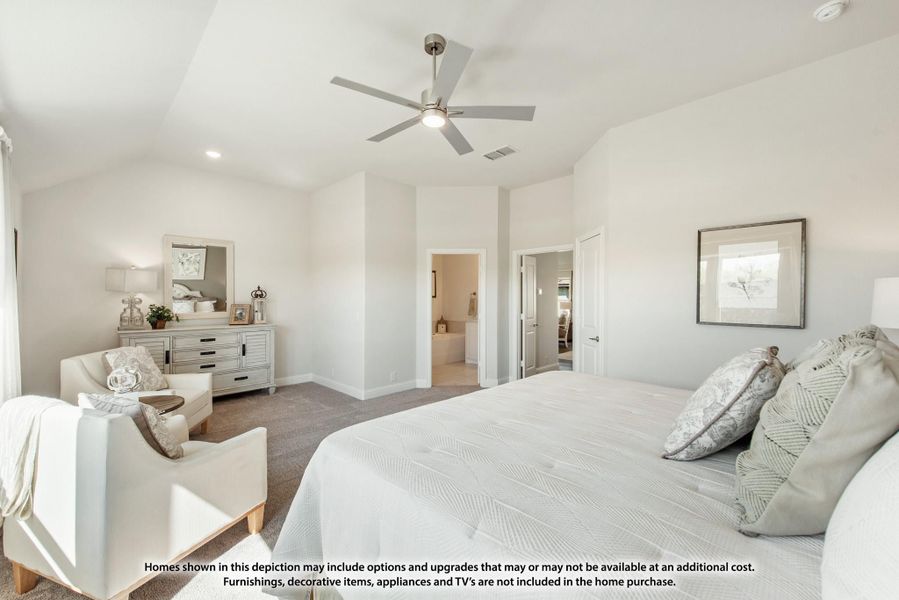 Master bedroom with vaulted ceiling, ceiling fan, carpet flooring, and doorway leading to ensuite bathroom Master bedroom with vaulted ceiling, ceiling fan, carpet flooring, and doorway leading to ensuite bathroom