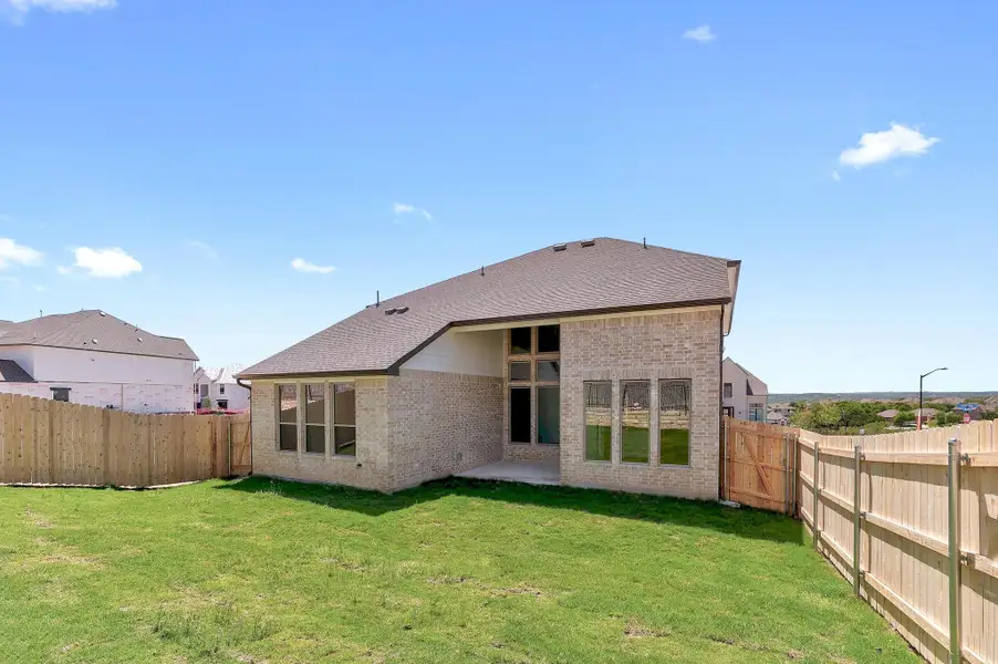 Back of property with brick siding, a fenced backyard, a patio, and a yard Back of property with brick siding, a fenced backyard, a patio, and a yard
