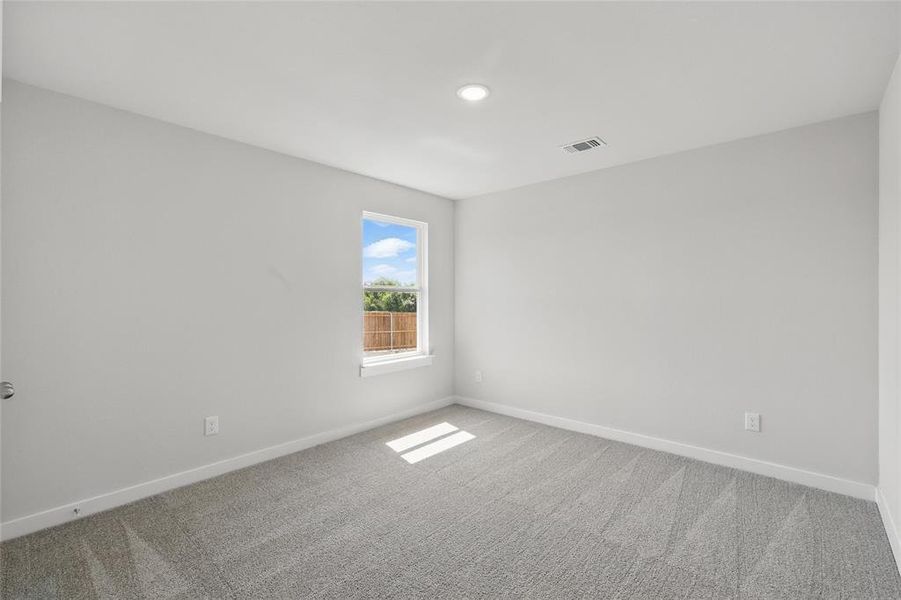 Empty room featuring light colored carpet and baseboards