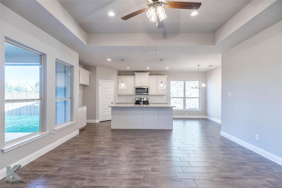 Kitchen featuring recessed lighting, dark wood finish ceramic tile floors, a kitchen island with sink, white cabinetry, and ceiling fan