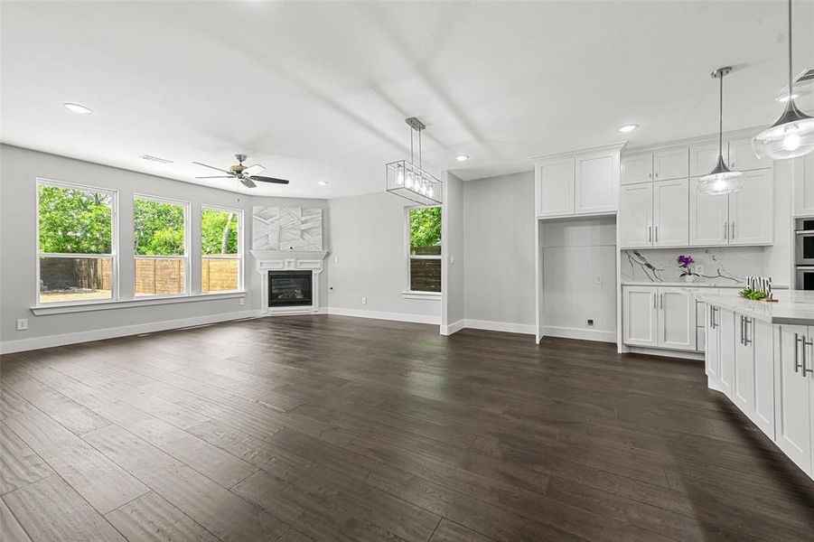 Unfurnished living room with ceiling fan and dark hardwood / wood-style flooring