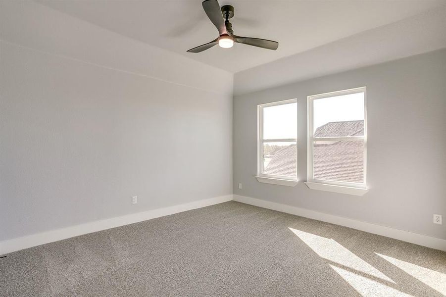 Carpeted empty room with baseboards and ceiling fan