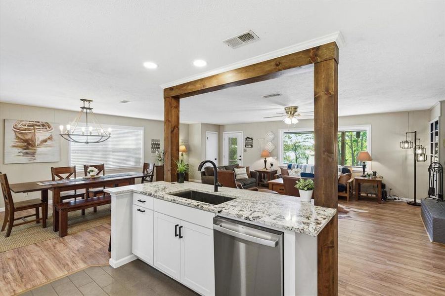 Kitchen island with granite countertop and undermount sink, stainless steel dishwasher, and recessed lighting