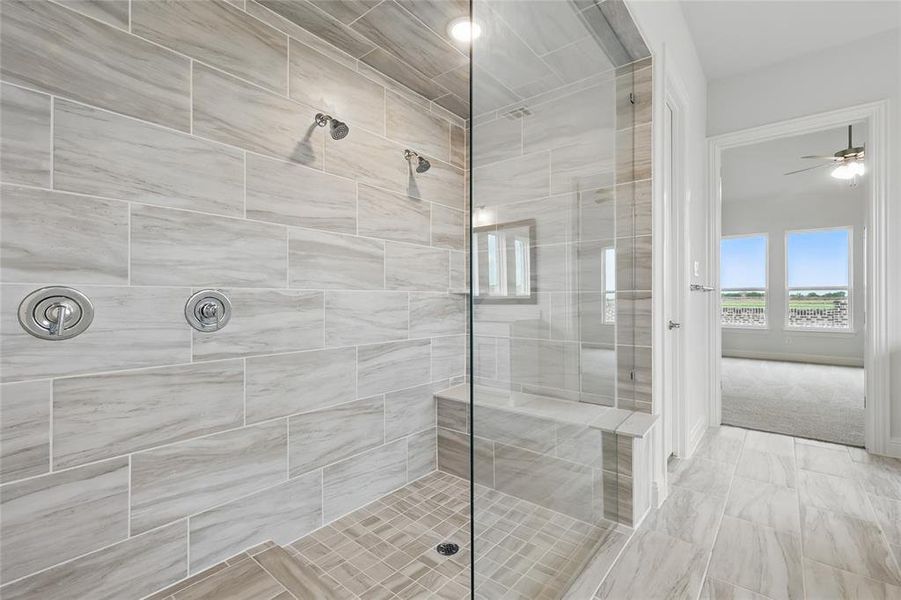 Bathroom with ceiling fan and tiled shower