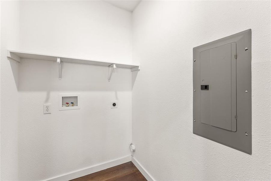 Utility area with wood-finish flooring, white walls, and built-in shelving